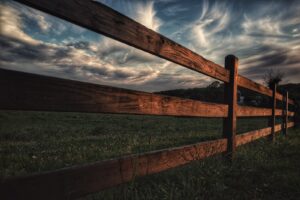brown wooden fence beside green grass field